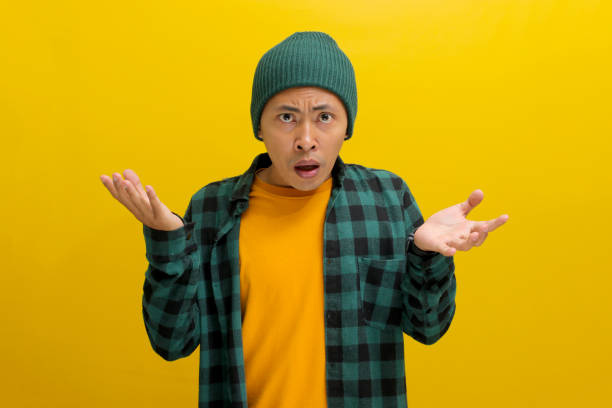 istock Confused young Asian man is expressing disbelief and perplexity, his hands spread sideways 2152125289