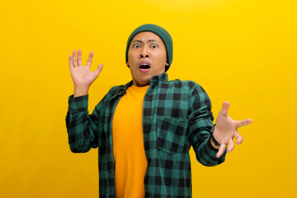 istock Excited young Asian man shouts WOW loudly, his hands expressing surprise 2152125874