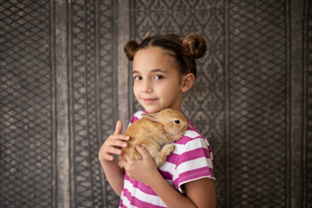 istock Portrait of girl hugging her pet rabbit 2152125885