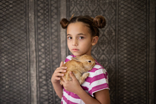 istock Portrait of girl hugging her pet rabbit 2152125905