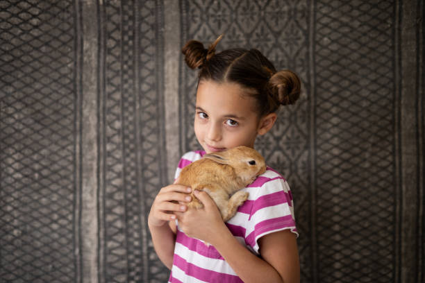 istock Portrait of girl hugging her pet rabbit 2152125907