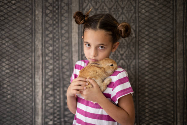 istock Portrait of girl hugging her pet rabbit 2152125910