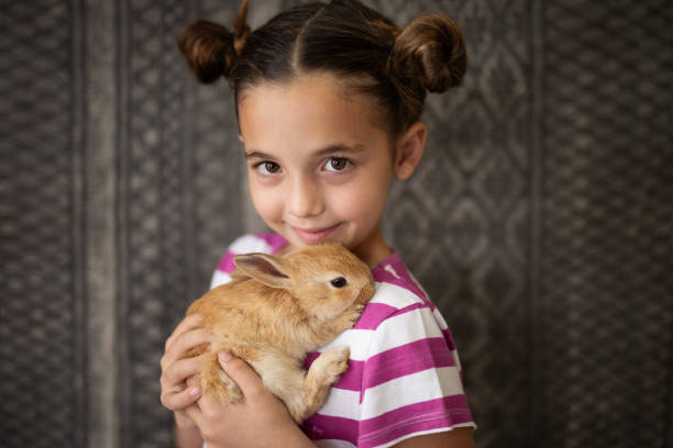 istock Portrait of girl hugging her pet rabbit 2152125920