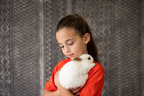 istock Portrait of girl hugging her pet rabbit 2152125955