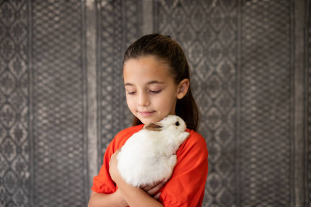istock Portrait of girl hugging her pet rabbit 2152125959