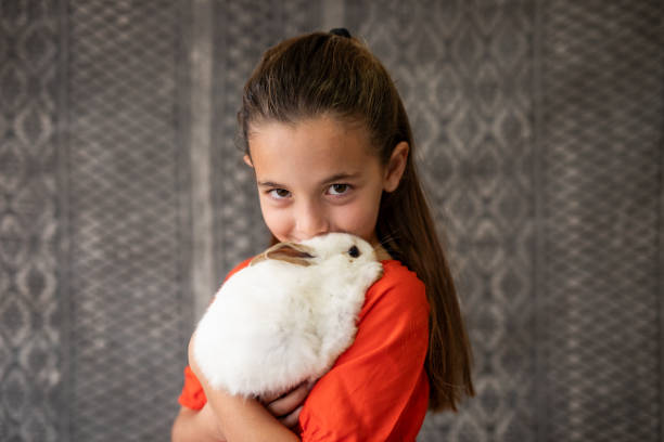 istock Portrait of girl hugging her pet rabbit 2152125962