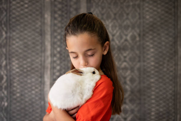 istock Portrait of girl hugging her pet rabbit 2152125967