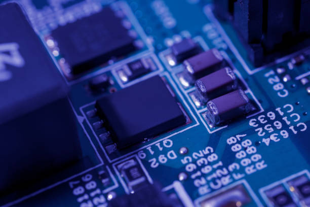 istock Green circuit board with a black integrated circuit chip and various small electronic components 2152127174