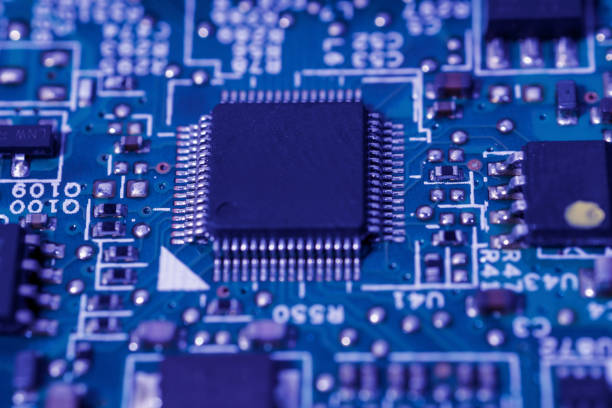 istock Green circuit board with a black integrated circuit chip and various small electronic components 2152127176