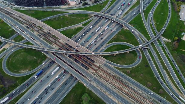 istock Aerial highway interlacing, rush hour traffic, urban dynamics captured. Traffic tapestry: Intertwining roads from above, a testament to urban planning and mobility. Motorway concept. 2152127992