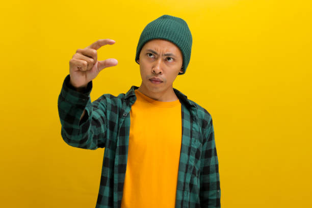 istock Displeased Asian man is gesturing a small size with his finger, indicating something not very big 2152133670