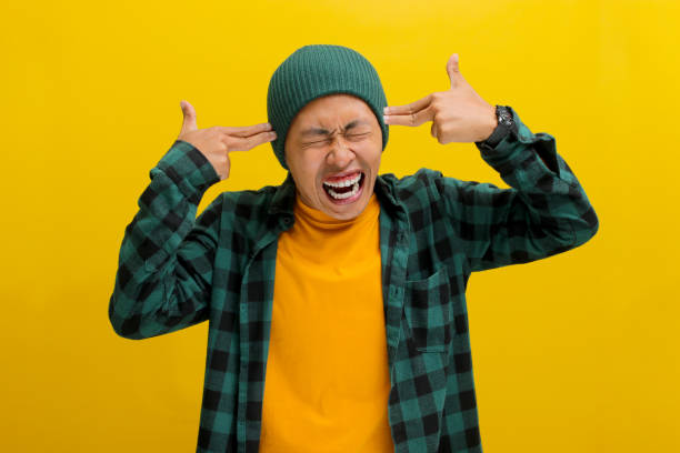 istock Distressed young Asian man is showing finger pistol gestures above his head 2152134056