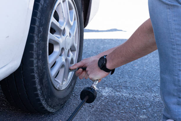 istock Man's hands inflating the wheel of a car 2152135875