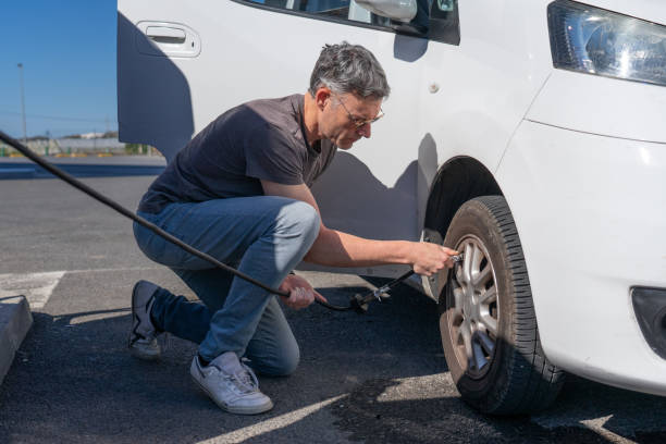 istock Caucasian man doing maintenance on his van before traveling, inflating the tires 2152135877