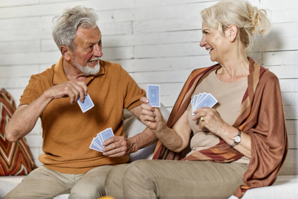 istock Happy senior couple talking while playing cards at home. 2152137442