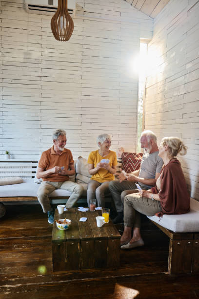 istock Happy senior couples enjoying while playing cards at home. 2152137837