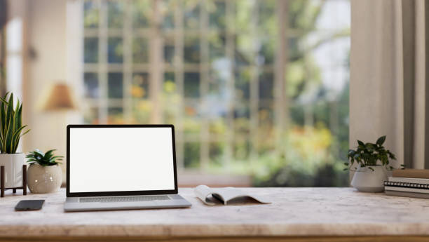 istock Home office workspace, a white-screen laptop computer mockup on a table in a comfortable room. 2152138238