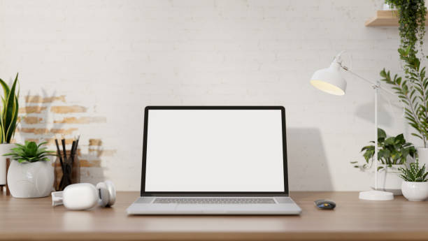 istock A minimalist workspace features a laptop computer mockup on a desk against the white brick wall. 2152139346