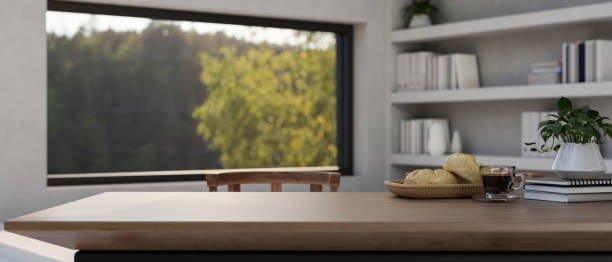 istock A copy space on a wooden table in a room with a bookshelf and a large window with a nature view. 2152139420