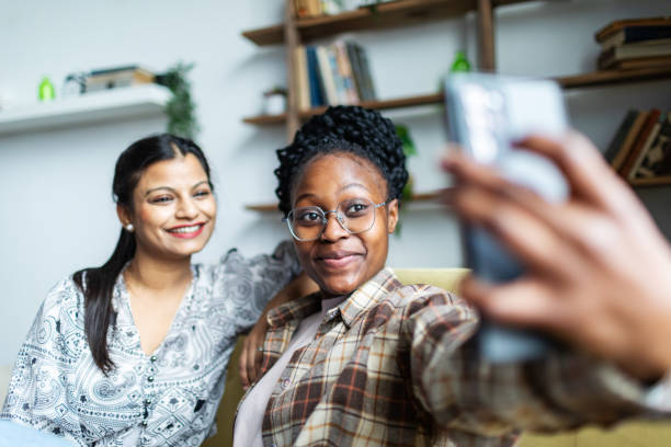 istock Two Young African and Indian women having fun at dorm and making selfie 2152141862