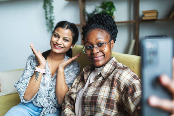 istock Two Young African and Indian women having fun at dorm and making selfie 2152141865