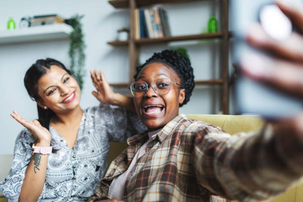 istock Two Young African and Indian women having fun at dorm and making selfie 2152141878