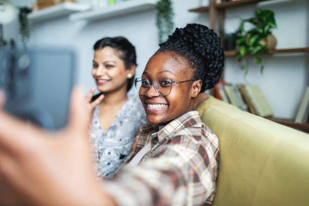 Two Young African and Indian women having fun at dorm and making selfie