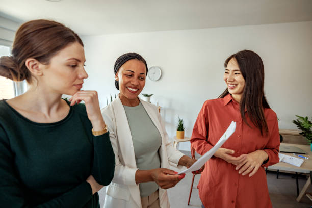 istock Female colleagues discussing work while standing at the office 2152142291