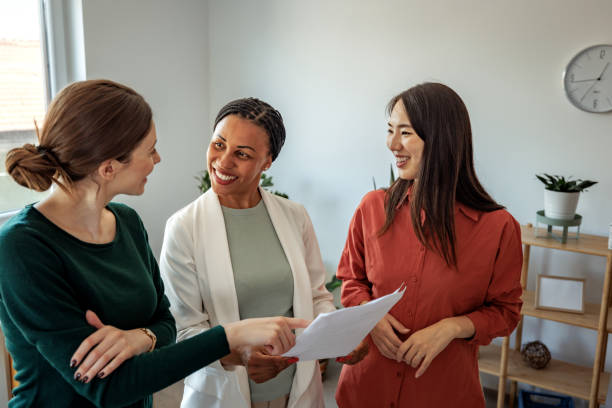 istock Female colleagues discussing work while standing at the office 2152142295
