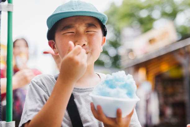 Asian boy eating shave ice.