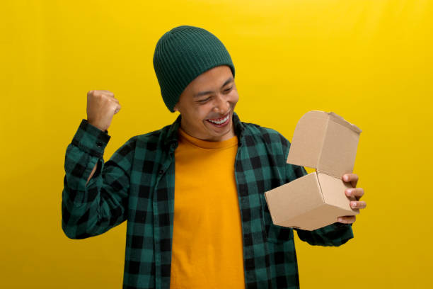 istock An excited Asian man eagerly unpacks the cardboard parcel package 2152143611