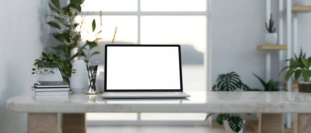 istock A modern home workspace features a laptop computer on a table surrounded by indoor houseplants. 2152145498