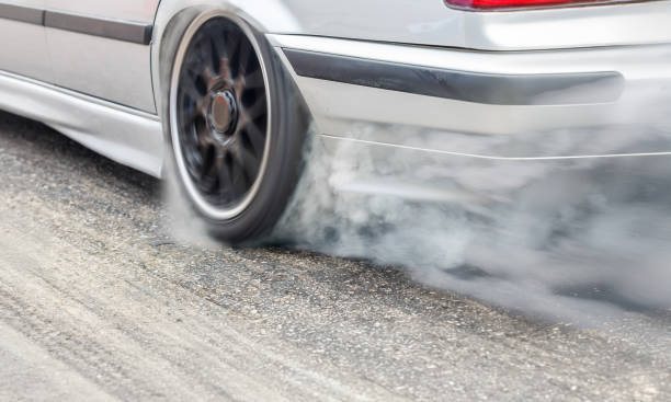 istock EV drag racing car is burning tire at start line. 2152146061