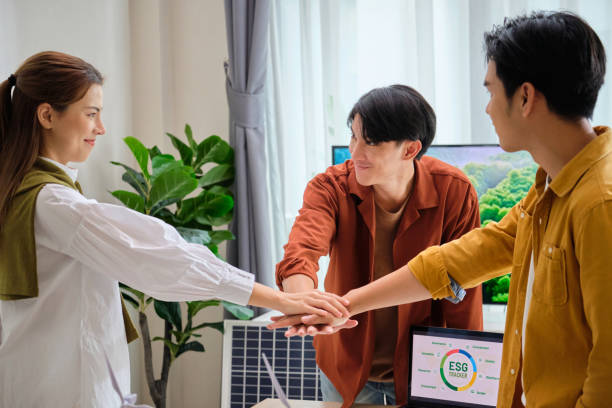 istock Group of Diversity business people joining stack hand teamwork unity,having a ESG meeting environment, society and governance, discussing renewable energy with wind turbine  and solar panel at office,Save the planet go green eco-friendly  net zero emissi 2152146455
