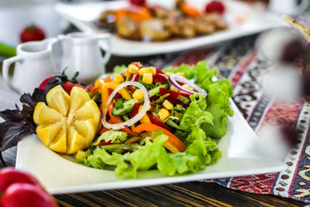 istock Fresh Salad on White Plate, Surrounded by Other Food 2152149798