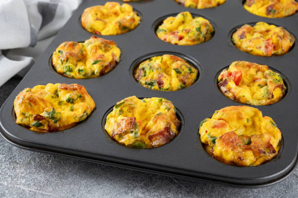 istock Egg muffins or egg bites with bacon, cheese, vegetables and herbs in a baking form on a concrete background. Healthy breakfast. 2152150109