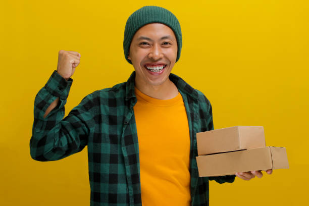 istock Happy Asian customer raises his arm in a YES gesture while holding package parcel cardboard box 2152151325