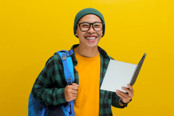 istock Happy young Asian student looks excited while holding a book 2152153466