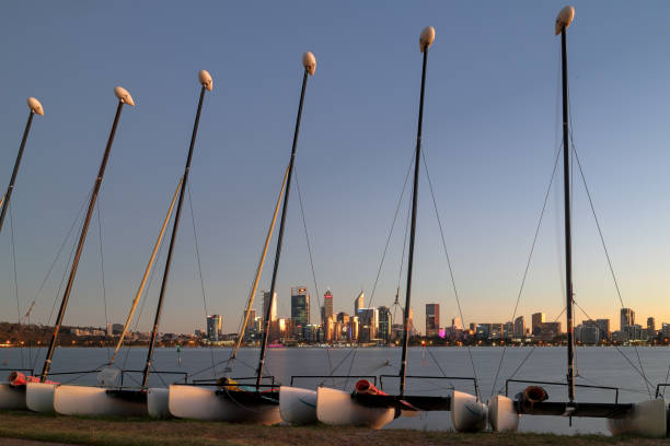 Dawn, twilight, sunrise, Perth central business district (CBD) seen from South Perth across Swan River, through masts of catamaran sailing boats