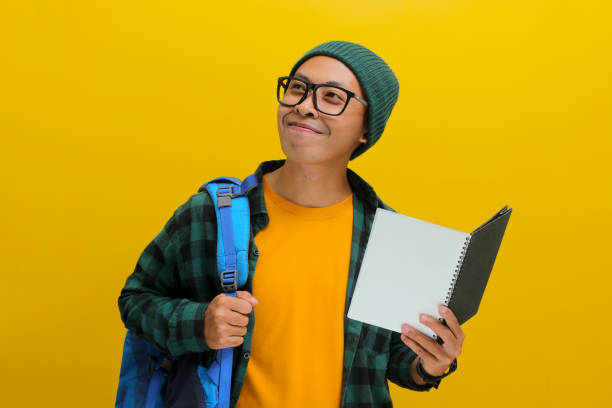 istock Happy young Asian student looks excited while holding a book 2152153837