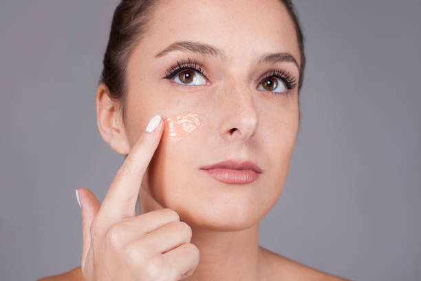 Woman applying foundation on her face