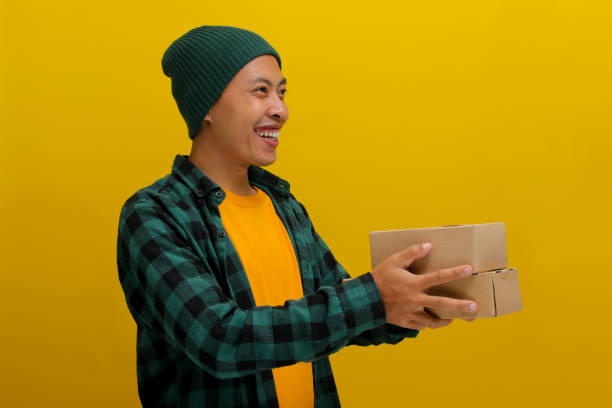 istock Side view of a young Asian man holding a cardboard box 2152155695