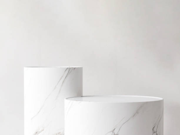 istock Two modern white marble pedestal podium, cylinder shape in sunlight on white background 2152156842