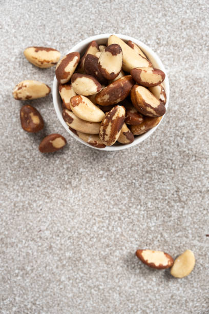 istock Brazil nuts in plate on grey background, space for text top view 2152159201