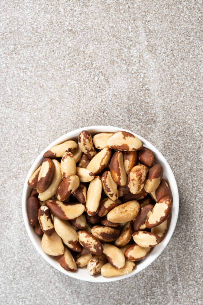 istock Brazil nuts in plate on grey background, space for text top view 2152159234
