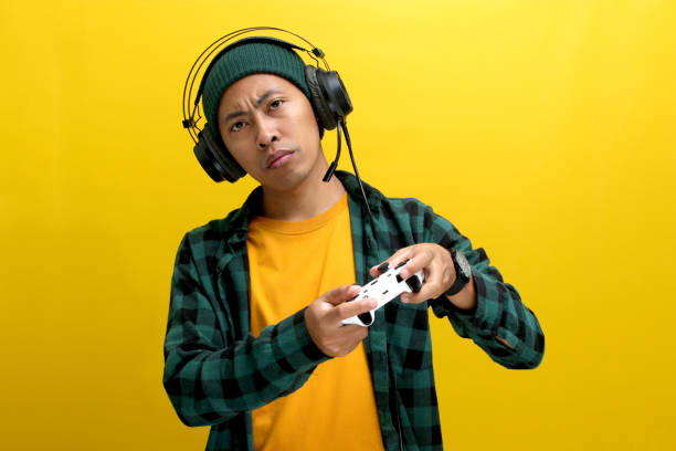 istock A bored Asian man appears disinterested while playing video games with a gamepad on a console 2152159290