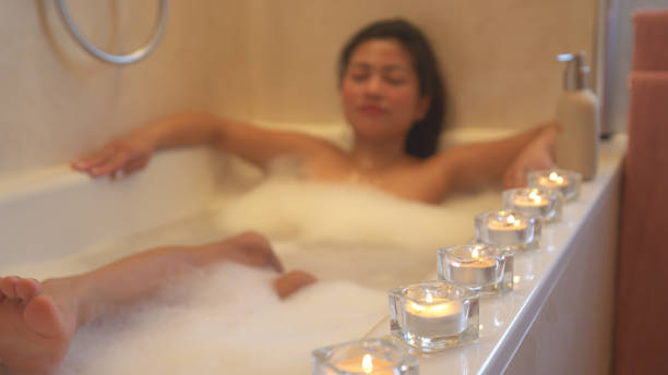 istock Attractive lady with eyes closed chilling in a bubbly bath embraced with candles 2152160274