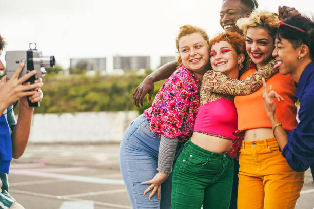 istock Young diverse people having fun with old vintage video camera outdoor - Main focus on left girls faces 2152160473