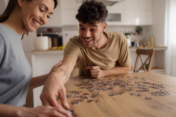 istock Happy man and his girlfriend having fun with puzzles at home. 2152160671