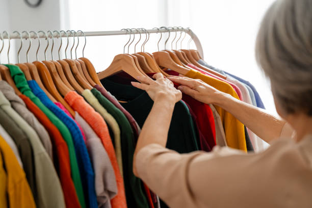 istock Woman browsing through colorful clothing on a rack 2152160676